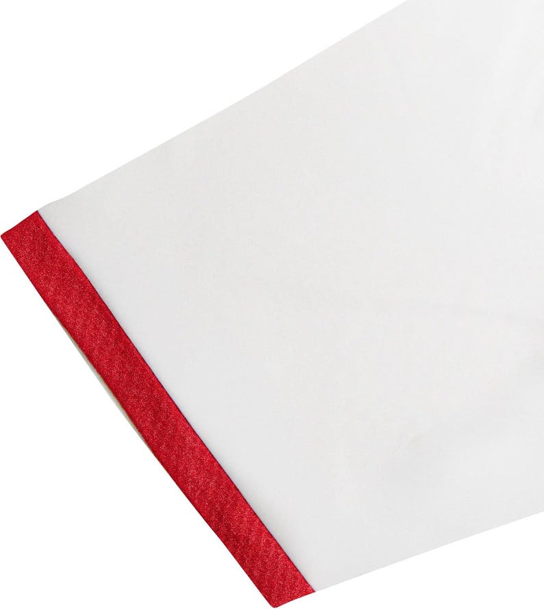 May include: Close-up of a white fabric with a vibrant red trim along the edge. The red trim has a textured appearance, creating a striking contrast against the smooth white surface. The fabric is angled.