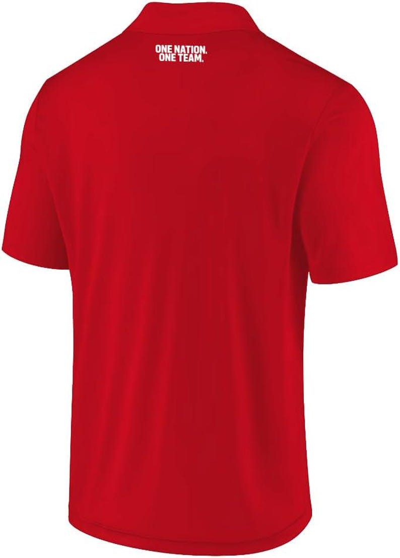 May include: A bright red short-sleeved polo shirt featuring a collar and a button placket. The upper back area displays the white text "ONE NATION. ONE TEAM." printed in a clean, sans-serif font, centered just below the collar neckline.