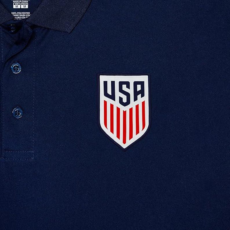 May include: A navy blue polo shirt with a white and red USA shield logo on the chest.
