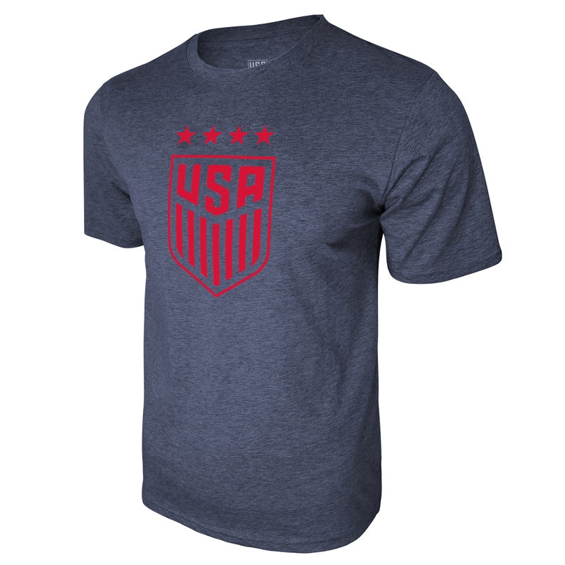 May include: A navy blue t-shirt with a red USA logo featuring five stars and vertical stripes. The logo is in the shape of a shield.