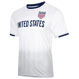 Pode incluir: Camisola de futebol branca com gola e acabamento das mangas azul-marinho. A camisola tem um padr&atilde;o de degrad&eacute; branco e cinza e apresenta o texto "UNITED STATES" e um escudo azul-marinho com as letras "USA" em vermelho.