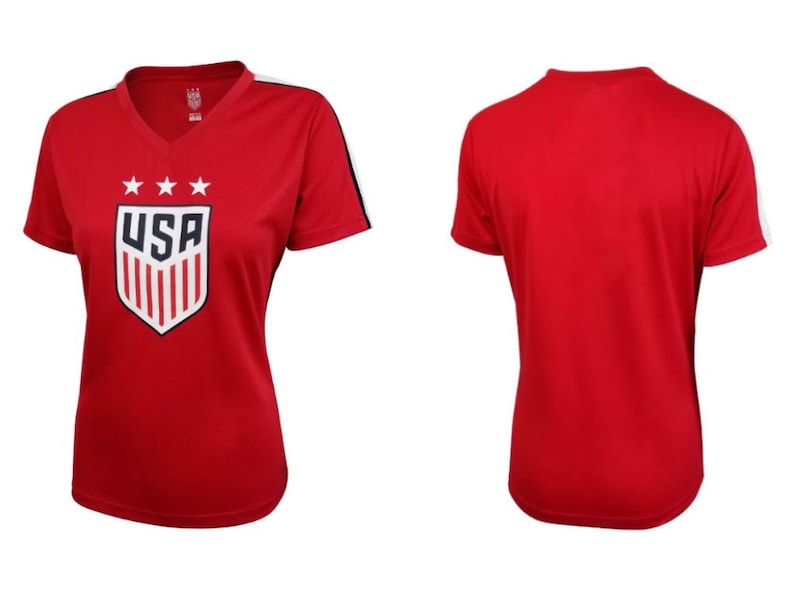 Pode incluir: Camiseta vermelha de manga curta com um bras&atilde;o dos EUA branco e azul com estrelas e listras. A camiseta tem listras brancas nas mangas.