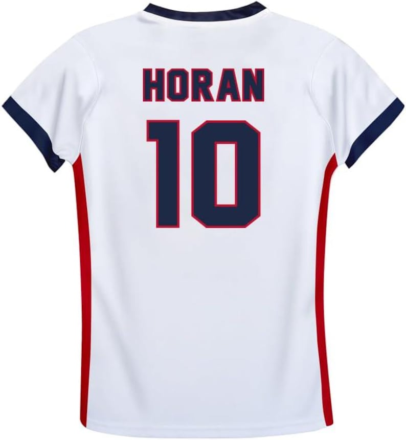 Pode incluir: Camisola de futebol branca com guarni&ccedil;&otilde;es vermelhas e azuis. A parte de tr&aacute;s da camisola tem o nome "HORAN" e o n&uacute;mero "10" impresso em azul com um contorno vermelho.