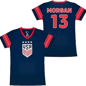 May include: Two navy blue soccer jerseys with red and white accents. One jersey has the text "USA" and a shield with stars. The other jersey has the text "MORGAN 13".