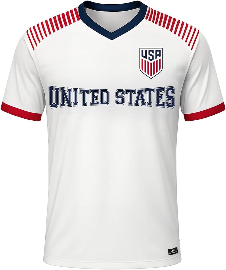 May include: White soccer jersey with red and blue accents. The jersey features a V-neck collar, red stripes on the shoulders, and red trim on the sleeves. The words "UNITED STATES" are across the chest, with the "USA" logo on the upper right.