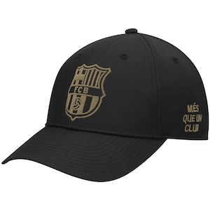 May include: Black baseball cap with a gold embroidered FC Barcelona logo and the text "Més que un club" on the side.