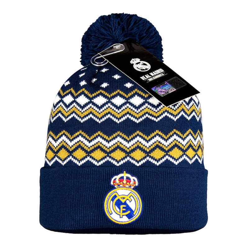 Puede incluir: Gorro de punto azul marino con pomp&oacute;n. El gorro presenta un patr&oacute;n de zigzag blanco y amarillo y un logotipo del Real Madrid. Una etiqueta con el logotipo del Real Madrid est&aacute; adjunta.