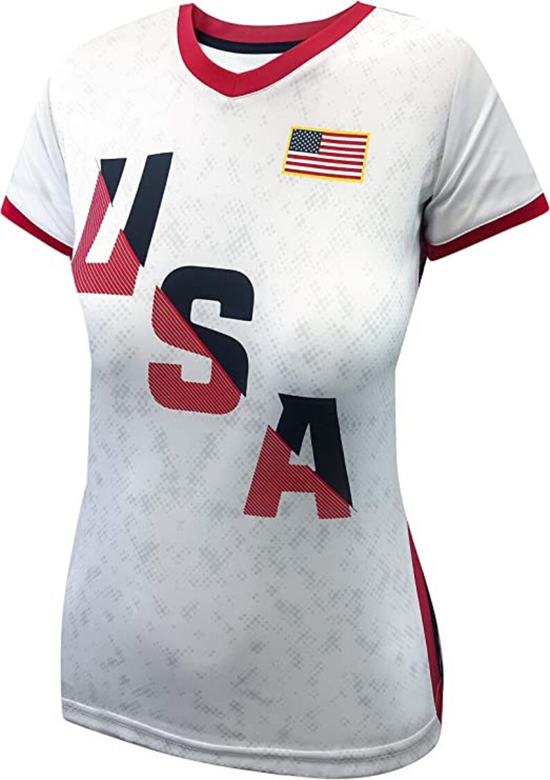 May include: White short-sleeved shirt with a red, white, and blue USA graphic and a small American flag on the chest.