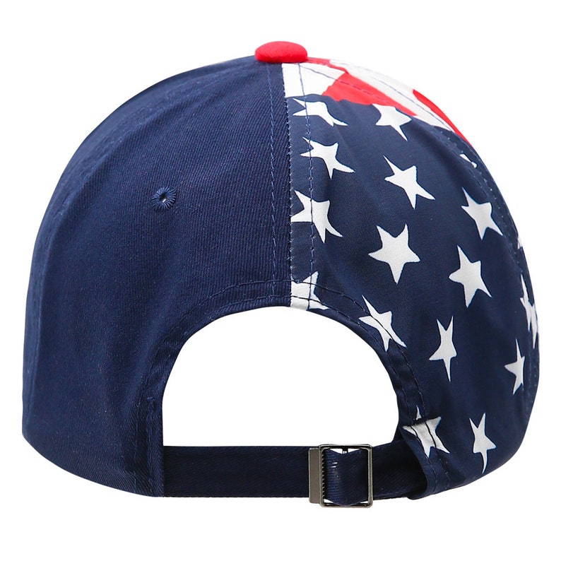 May include: A navy blue baseball cap with a white star pattern on the back half of the cap. The front of the cap is solid navy blue. The cap has a red button on top and a navy blue adjustable strap.