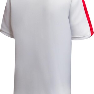 May include: White short-sleeved t-shirt with red accents. The shirt features a red stripe down the shoulder and around the neckline. The back of the shirt is visible, showcasing the simple design and color scheme. This athletic-style shirt is suitable for sports or casual wear.