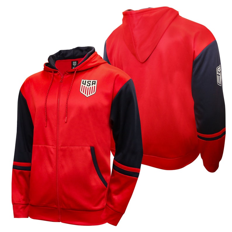 May include: Red and navy blue zip-up hoodie with a USA logo on the front. The hoodie has a drawstring hood and two pockets.