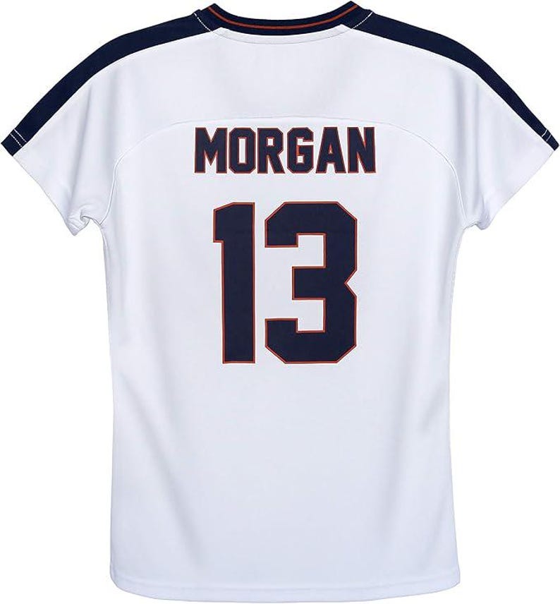 May include: White athletic jersey with the name "MORGAN" and the number "13" in navy blue with orange trim. The jersey has navy blue shoulder accents and a navy blue and orange trim on the collar.
