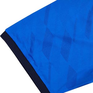 May include: Close-up of a blue athletic shirt with a textured pattern. The shirt has a dark blue collar and a diamond-shaped design. The fabric appears to be a breathable, moisture-wicking material.