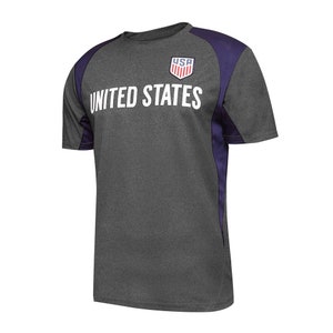 May include: A gray and purple short-sleeved t-shirt with the words "UNITED STATES" and a small "USA" logo on the front.