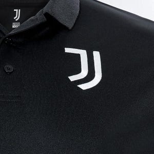 May include: Black polo shirt with a white "J" logo on the right side of the chest. The shirt has a button-up collar and a single button on the left side of the chest.