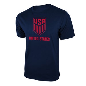 May include: A navy blue t-shirt with a red USA logo and the words "UNITED STATES" printed on the front.