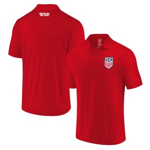 May include: Red short-sleeved polo shirt with a small embroidered USA logo on the left chest. The back of the shirt has the text "ONE NATION, ONE TEAM" printed in white.