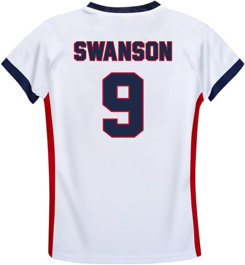 May include: White soccer jersey with red and blue trim. The back of the jersey has the name "SWANSON" and the number "9" printed in blue with a red outline.