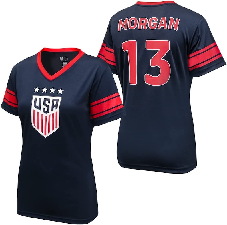 May include: A navy blue football shirt with red and white accents. The shirt has the word "USA" and three stars on the front, and the number "13" and the name "MORGAN" on the back.