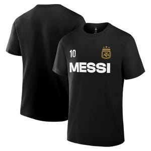 May include: Black t-shirt featuring the name "MESSI" in white block letters, with the number "10" above it. The shirt also displays a gold emblem with the letters "AFA". Another black t-shirt is visible in the background.