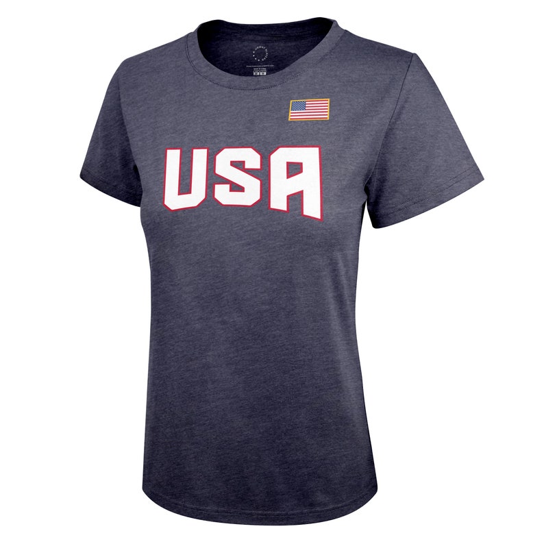 K&ouml;nnte beinhalten: Ein marineblaues T-Shirt mit einem wei&szlig;en "USA"-Aufdruck und einem kleinen amerikanischen Flaggen-Patch auf der rechten Brust.