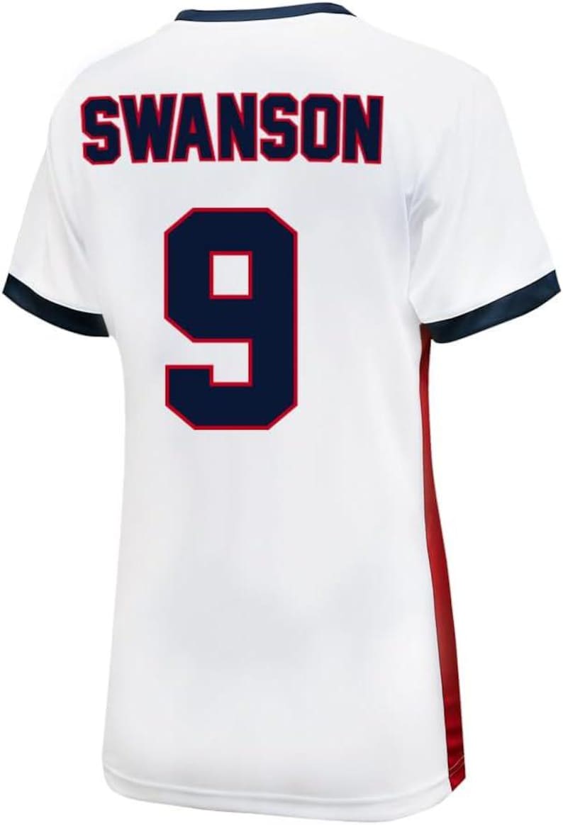 K&ouml;nnte beinhalten: Wei&szlig;es Fu&szlig;balltrikot mit blauen und roten Verzierungen. Auf der R&uuml;ckseite des Trikots steht der Name "SWANSON" und die Nummer "9" in Marineblau mit rotem Umriss.