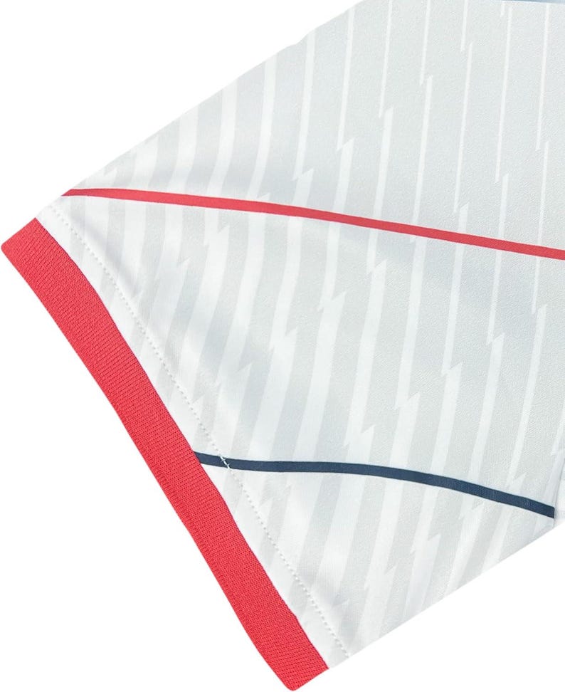 May include: Close-up of a white athletic shirt with a pattern of vertical grey stripes and lightning bolt shapes. The shirt has red trim on the sleeve and a red stripe across the chest. A thin navy blue stripe is also visible.