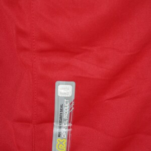 May include: A red shirt with a gray and white security seal tag that reads "Official Product" and "Rhino X Security Seal".