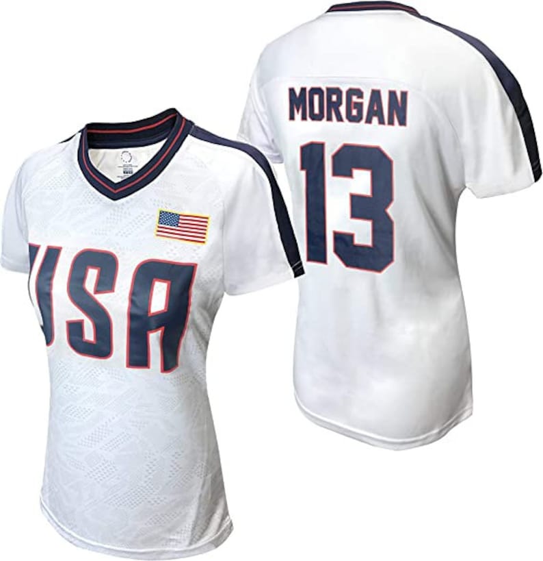 K&ouml;nnte beinhalten: Wei&szlig;es Fu&szlig;balltrikot mit blauen und roten Akzenten. Das Trikot hat "USA" auf der Vorderseite und "MORGAN 13" auf der R&uuml;ckseite.