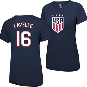 Puede incluir: Camiseta azul marino con letras blancas que dicen "Lavelle 16". La camiseta tiene cuello redondo y mangas cortas. La parte posterior de la camiseta tiene un logotipo de EE. UU. rojo, blanco y azul con cinco estrellas arriba.
