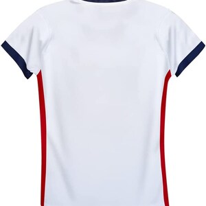 May include: White short-sleeved t-shirt with red and navy blue trim. The shirt has a crew neck and a plain front.