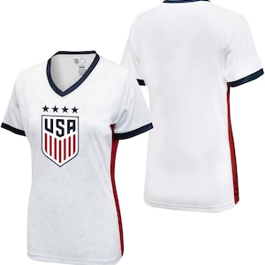 May include: White football shirt with a red, white and blue USA crest on the front. The shirt has navy blue trim on the collar and sleeves and red side panels.