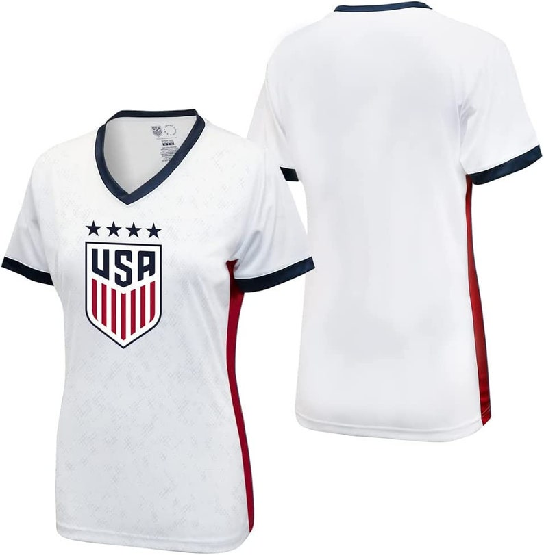 May include: White football shirt with a red, white and blue USA crest on the front. The shirt has navy blue trim on the collar and sleeves and red side panels.