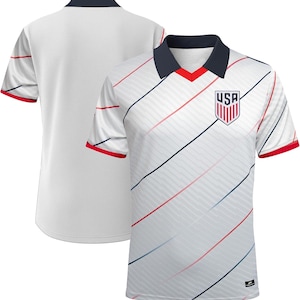 May include: White football shirt with diagonal red and blue stripes. The shirt has a navy blue collar with a red V-neck and red trim on the sleeves. The USA emblem is on the chest.