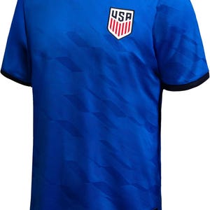May include: Royal blue soccer jersey with a geometric pattern and black trim. The jersey features the USA emblem on the chest. The shirt is short-sleeved and has a crew neck.