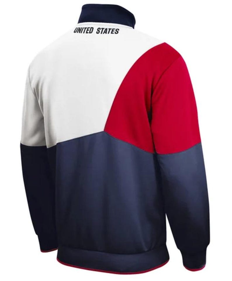 Puede incluir: Una chaqueta con cremallera blanca, roja y azul marino con las palabras "UNITED STATES" en la espalda.