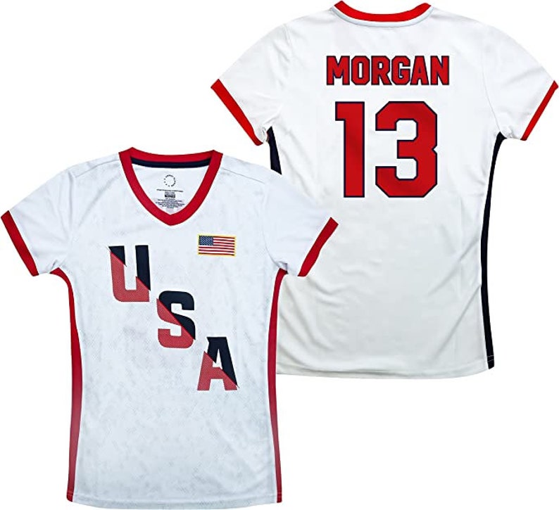 May include: White soccer jersey with red and blue USA lettering and an American flag on the front. The back of the jersey has the name "MORGAN" and the number "13" in red.