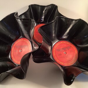 May include: Three black bowls crafted from repurposed vinyl records with wavy, flared edges. Each bowl features a central red Columbia record label with text reading Bruce Springsteen & The E Street Band Live 1975-85, creating a unique display.