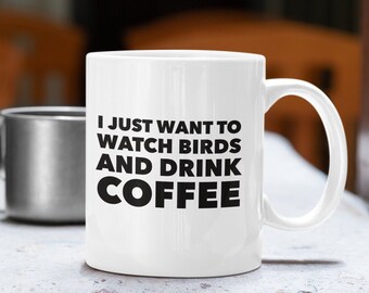 May include: White ceramic coffee mug with black text that reads "I just want to watch birds and drink coffee".