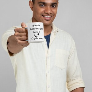 May include: White ceramic mug with black text that reads "If you're happy and you know it it's your meds" with a graphic of two pills.