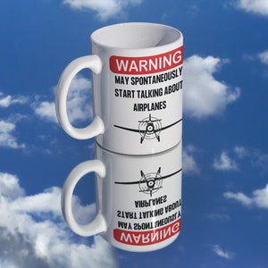 May include: White ceramic mug with a red warning sign that reads "WARNING MAY SPONTANEOUSLY START TALKING ABOUT AIRPLANES". A black and white illustration of a small airplane is printed on the mug.