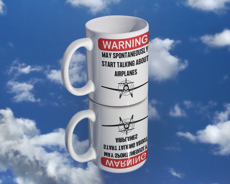 May include: White ceramic mug with a red warning sign that reads "WARNING MAY SPONTANEOUSLY START TALKING ABOUT AIRPLANES". A black and white illustration of a small airplane is printed on the mug.
