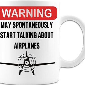 May include: White ceramic mug with a red warning sign that says "WARNING MAY SPONTANEOUSLY START TALKING ABOUT AIRPLANES". A black silhouette of a small airplane is at the bottom of the mug.