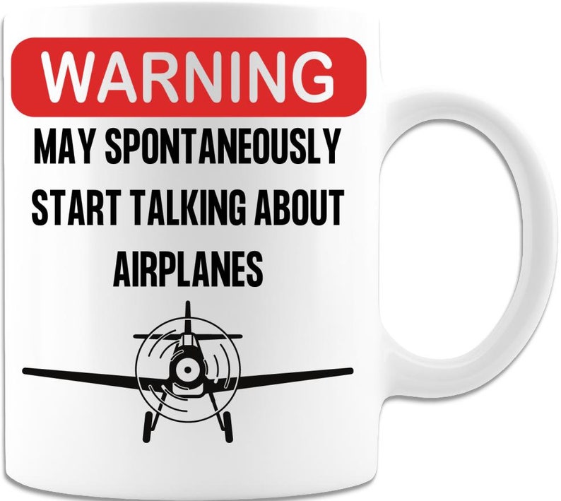 May include: White ceramic mug with a red warning sign that says "WARNING MAY SPONTANEOUSLY START TALKING ABOUT AIRPLANES". A black silhouette of a small airplane is at the bottom of the mug.