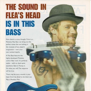 May include: A blue electric bass guitar with a sparkly finish. The guitar is held by a man wearing a black fedora. The text "The Sound in Flea's Head is in this Bass" is at the top of the image. The text "Modulus Guitars® The Power of Carbon Fiber" is at the bottom of the image.