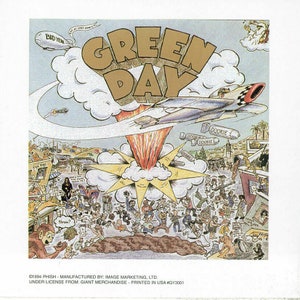 May include: A cartoon illustration of a band performing in front of a mushroom cloud explosion. The band's name, "Green Day", is written in large, gold letters at the top of the image. The image is surrounded by a white border.
