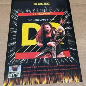 May include: A rectangular advertisement poster featuring a guitarist playing a diamond-shaped electric guitar. The text reads LIVE WIRE HERE, HI-VOLTAGE, THE HANDMADE STRING, and DAMAGEPLAN. The background displays white lightning bolts and orange flames.