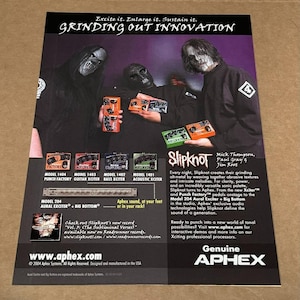 Puede incluir: Un anuncio en blanco y negro para los pedales de efectos de audio Aphex con la banda Slipknot. El anuncio presenta una foto de los miembros de la banda y una variedad de pedales Aphex, incluyendo la Punch Factory, la Guitar Xciter, la Bass Xciter, la Acoustic Xciter, la Aural Exciter y la Big Bottom. El texto del anuncio destaca el uso de los pedales Aphex por parte de Slipknot y los beneficios de usar los pedales Aphex para crear una variedad de sonidos.