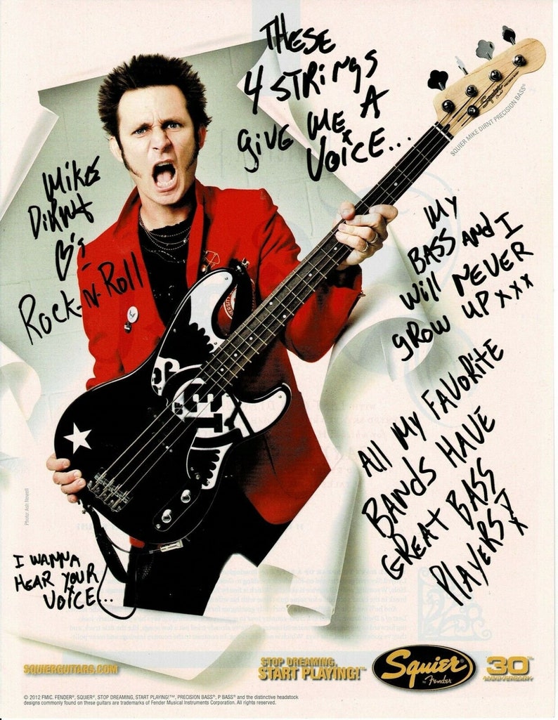 May include: An advertisement featuring a black and white bass guitar with a star design, held by a person wearing a red jacket. Text includes "These 4 strings give me a voice..." and "I wanna hear your voice..." The Squier Fender logo is visible.
