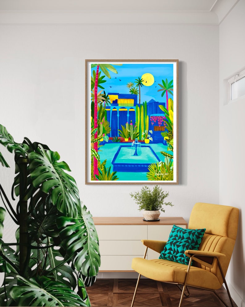 May include: A framed illustration of a blue building with a fountain in a courtyard. The building has a yellow roof and is surrounded by palm trees and other plants. The sky is blue and there is a yellow sun in the upper right corner.